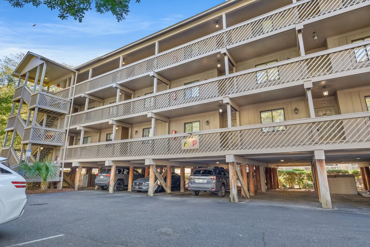 The image shows the exterior of Shipwatch Pointe II, with multiple balconies, entrance doors, and a parking area. The building facade is welcoming and well-maintained, suggesting a comfortable and accessible environment for extended stays. The atmosphere feels inviting, ideal for snowbirds looking for a home-away-from-home during the winter months.